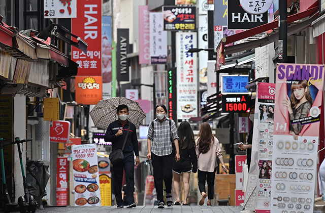 People walk through the Myeongdong shopping district in Seoul on Thursday (AFP photo)